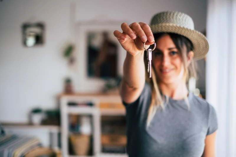 A woman holds a key inside her new home.